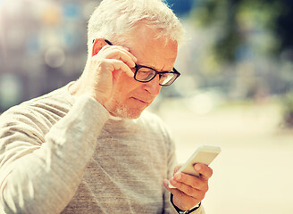 Image showing senior man texting message on smartphone in city