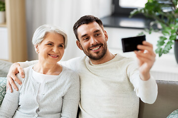 Image showing senior mother with adult son taking selfie at home