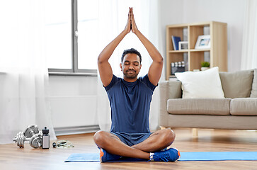 Image showing indian man meditating in lotus pose at home