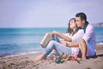Image showing young couple enjoying  picnic on the beach