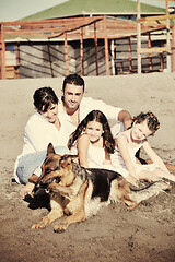 Image showing happy family playing with dog on beach