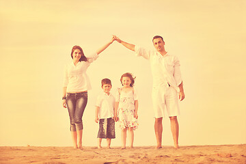 Image showing family on beach showing home sign