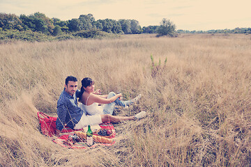 Image showing happy couple enjoying countryside picnic in long grass