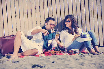 Image showing young couple enjoying  picnic on the beach