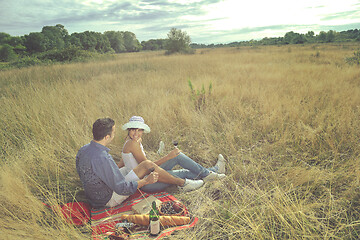 Image showing happy couple enjoying countryside picnic in long grass