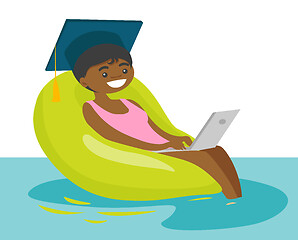 Image showing Graduate working on a laptop in the swimming pool.