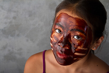 Image showing young asian girl having fun with a chocolate mask