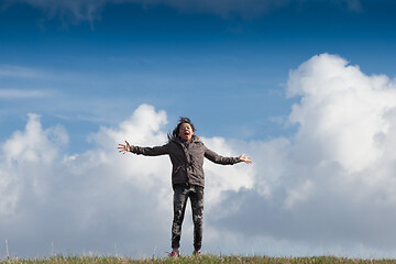 Image showing Cute girl running jumping at the on a field in the summer