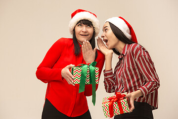 Image showing Happy family in Christmas sweater posing on a red background in the studio.