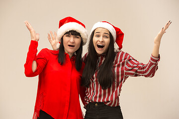 Image showing Happy family in Christmas sweater posing on a red background in the studio.