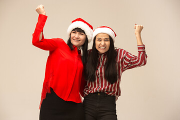 Image showing Happy family in Christmas sweater posing on a red background in the studio.