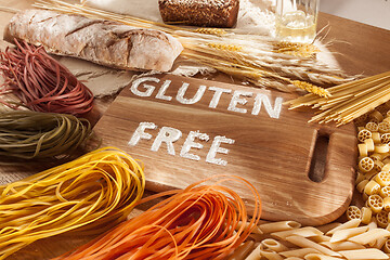 Image showing Gluten free food. Various pasta, bread and snacks on wooden background from top view