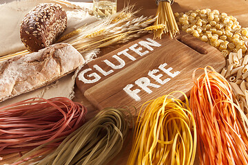 Image showing Gluten free food. Various pasta, bread and snacks on wooden background from top view