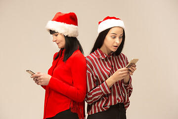 Image showing Happy family in Christmas sweater posing on a red background in the studio.