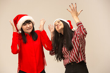 Image showing Happy family in Christmas sweater posing on a red background in the studio.