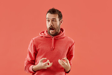 Image showing The squint eyed man with weird expression isolated on coral