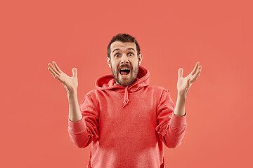 Image showing The young attractive man looking suprised isolated on coral