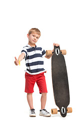 Image showing Full length portrait of an adorable young boy riding a skateboard isolated against white background