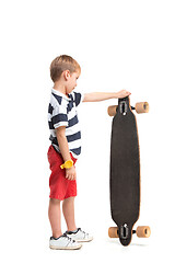 Image showing Full length portrait of an adorable young boy riding a skateboard isolated against white background