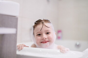 Image showing little girl in bath playing with soap foam