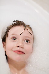 Image showing little girl in bath playing with soap foam