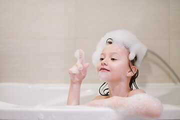 Image showing little girl in bath playing with soap foam