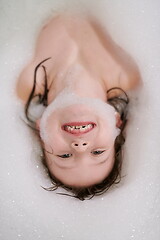 Image showing little girl in bath playing with soap foam