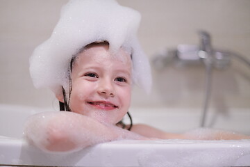 Image showing little girl in bath playing with soap foam