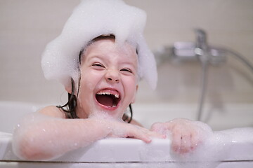 Image showing little girl in bath playing with soap foam