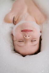 Image showing little girl in bath playing with soap foam