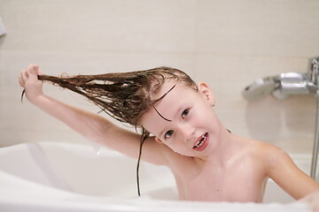 Image showing little girl in bath playing with soap foam