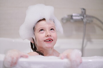 Image showing little girl in bath playing with soap foam