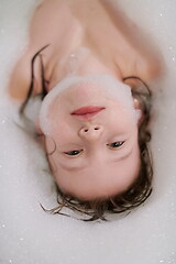 Image showing little girl in bath playing with soap foam