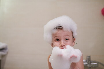 Image showing little girl in bath playing with soap foam