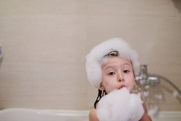 Image showing little girl in bath playing with soap foam