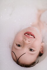 Image showing little girl in bath playing with soap foam