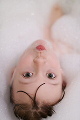 Image showing little girl in bath playing with soap foam