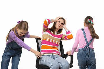 Image showing Two daughters are spinning mom in an office chair, mom is spinning