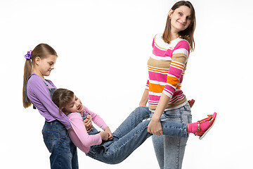 Image showing Mom and the eldest daughter took the youngest daughter by the arms and legs