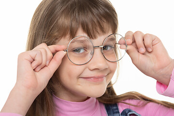 Image showing Happy girl adjusts his glasses and looks into the frame, close-up