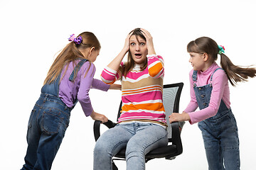 Image showing Two daughters unwind mom in an office chair