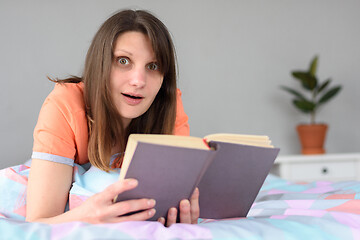 Image showing The girl in a slight shock from reading in a book