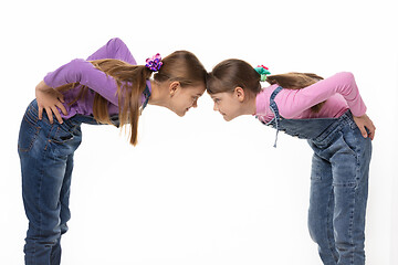 Image showing quarrel two girls standing leaning their foreheads against to each other