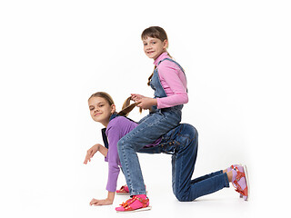 Image showing Two girls play horse on a white background