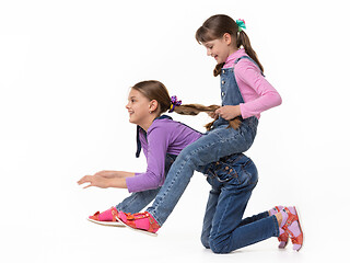 Image showing Girl rides another girl on herself on a white background