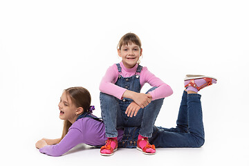 Image showing Happy girl sits on her sister\'s back in a white background