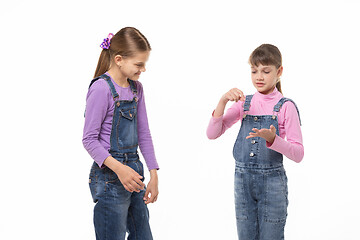 Image showing The girl explains to her sister the meaning of the hidden word in the game