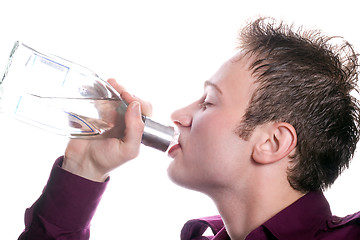 Image showing The young man drinks vodka from a bottle