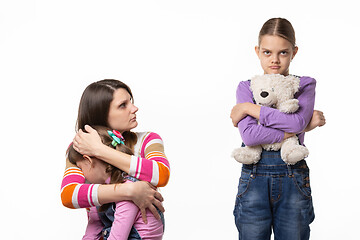 Image showing Mom reproachfully looks at the eldest daughter for offending the younger daughter