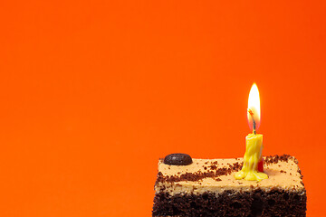 Image showing Small candle on a pie on a bright red background